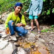Au sein du parc Amboro, du pétrole  affleure directement en surface. Il est utilisé par les populations locales, qui n'ont pas l'électricité, pour s'eclairer a l'aide de lampes à pétrole improvisees. Ils font donc plusieurs heures de marche pour aler collecter directement ce pétrole arrivant en surface, et polluant naturellement la rivière... Bolivie.