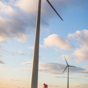 Petite fille dans la campagne devant des eoliennes. Futur. Developpement durable - Generations futures - Energie -