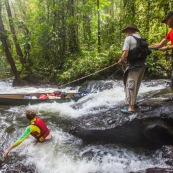 Passage de canoe dans la foret tropicale amazonienne. Expedition en Guyane.  Arret observation en haut d'un saut, chute d'eau. Passage du saut a la corde (cordelle).