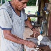 Decoupe du manioc (cramagnoc) dans un carbet en foret. Perou. Dans la cuisine.