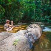 Baignade a Saul en foret tropicale amazonienne. Riviere. Crique. Sentier Roche bateau. En famille. Avec des enfants et bebe. Bain dans une crique sablonneuse.  Maman et sa fille. Tourisme.  Parc amazonien de Guyane.