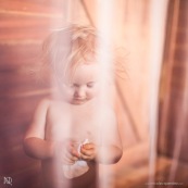 Petite fille (bebe) derriere une moustiquaire.