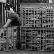 Ouvrière chinoise triant des produits dans une usine de fabrication de pièces métalliques. Made in china. Conditions de travail difficiles, conditions précaires. L'ouvrière est accroupie à même le sol. 
Noir et blanc.