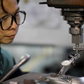 Usine chinoise de fabrication de moules d'injection de pieces plastiques. Ici un moule de piece plastique pour roller. Ouvrier en train de controler un moule, qui servira a injecter les pieces plastiques. Chine, Shenzhen, usine du monde. Travail plus de 70 heures par semaine, a faible couts, pour utilisation des produits par les pays "riches".