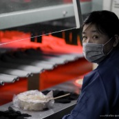 Ouvriere chinoise dans une usine en Chine. Process chaussure. Devant un four ou seche la colle.