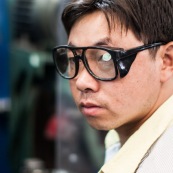 Ouvrier chinois dnas une usine en Chine avec des lunettes de protection. Il n'a pas enlevé le sticker des lunettes !