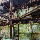 Ancienne rhumerie a Matoury, Guyane francaise. Batiment industriel rouille. Murs en briques. Etages en train de se decomposer. Rouille.