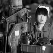 Ouvriere chinoise sur machine a riveter dans une usine de fabrication de chaussures en Chine. Made in china. Conditions de travail difficiles plus de 70 heures par semaine, pour fabriquer les produits utilises par les pays "riches". Le cout de la main d'oeuvre y est tres faible. Assemblage de rollers.