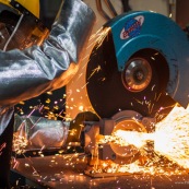 Usine a Taiwan (chine asie). Decoupe de pieces metalliques  avec une meule. Etincelles.